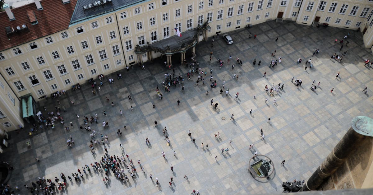 5 go down - 6 come back - who is the sixth? - From above of travelers on square in front of aged vintage panoramic exploring sightseeing and studying place in daylight