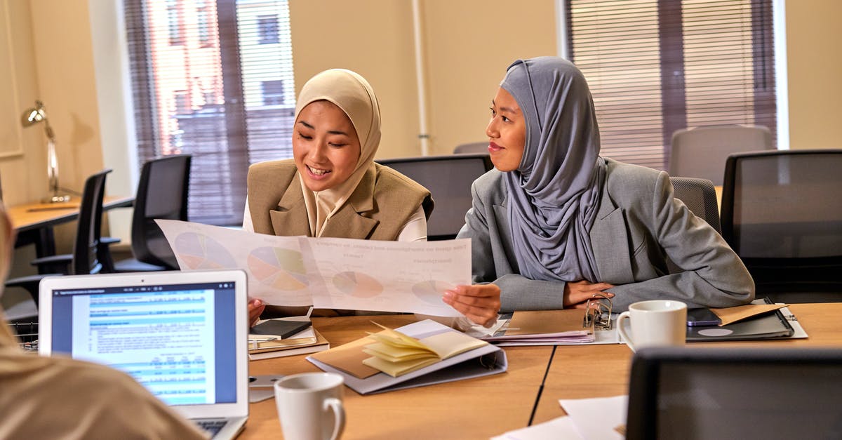 About Gargantua and Cooper? - Muslim Female Colleagues Talking About Task in Office Room