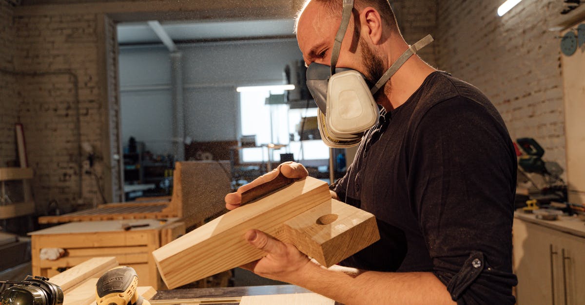 About the phrase Balian has in his workshop - Man in Black T-shirt Wearing White Face Mask Holding Brown Wooden Board