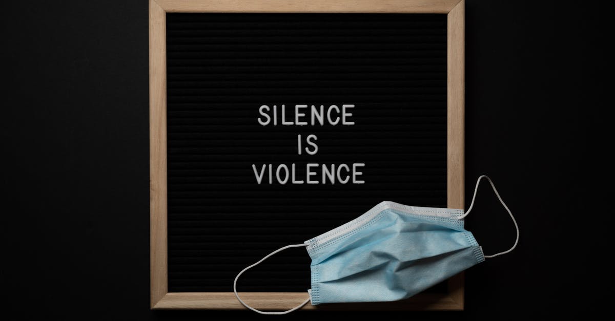 Aphorisms and idioms in The Witcher - Composition of framed Silence Is Violence inscription on black background with face mask