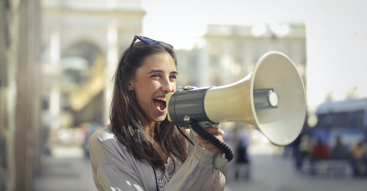 Are content rating criteria applied to music videos? - Cheerful young woman screaming into megaphone