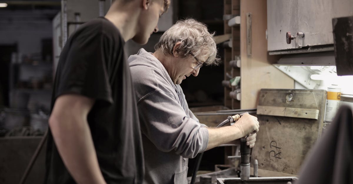 Are Snoke bodyguards old Jedi trainees? - Side view of senior artisan in eyeglasses handling detail in workshop while apprentice looking at process