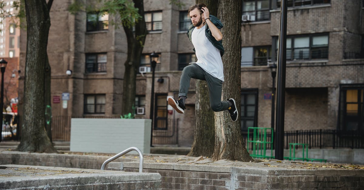 Are there union rules requiring stunt performers, and what does this mean for action stars who "do their own stunts"? - Side view of young bearded man in casual outfit doing parkour in city park