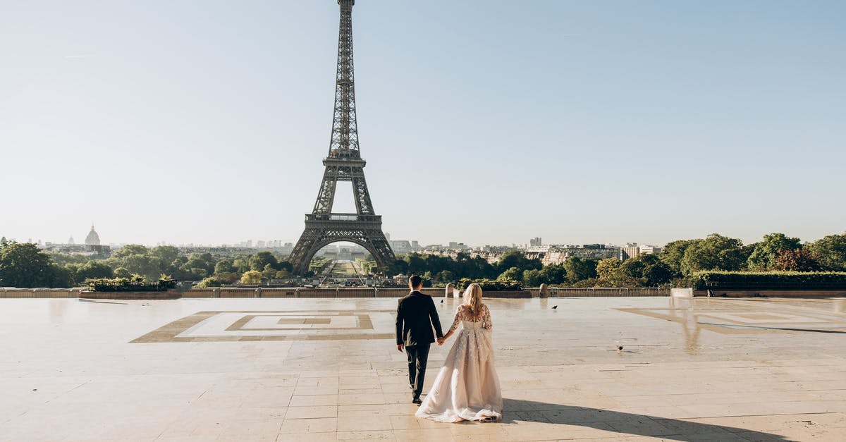 Are they in France or Portugal at the end of Love Actually? - Woman and Man Walking in Park in Front of Eiffel Tower