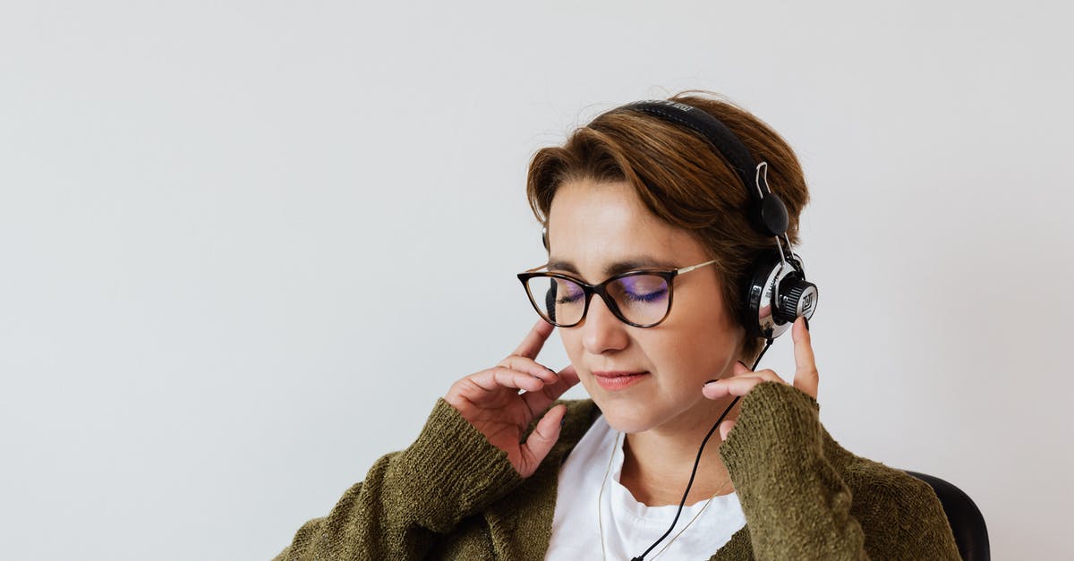 Are those apartments in The Wire abandoned? - Content glad female wearing eyeglasses and headphones listening to good music and touching headset while sitting with eyes closed against white wall