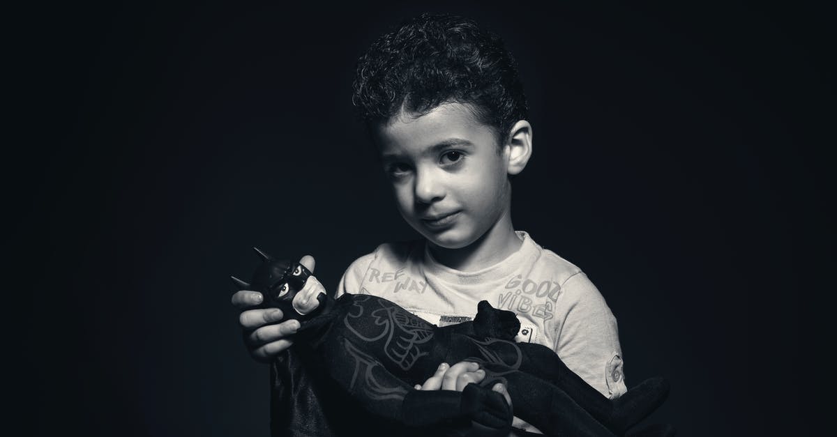 Batman is what? - Grayscale Photo of a boy Holding Batman Plush Toy