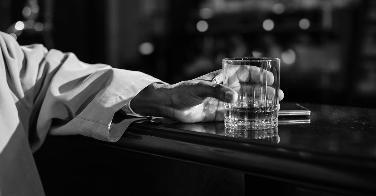 Breaking a whiskey glass with your bare hands: how would this have been done? - Close-Up Photo of Person Holding Clear Drinking Glass