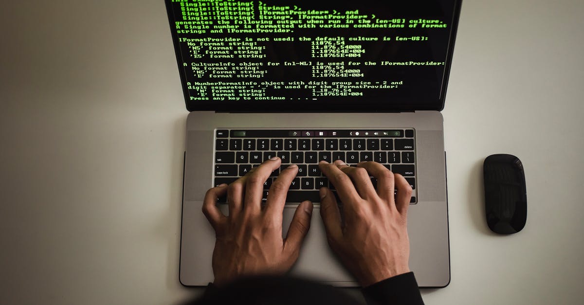 Can using fake names or pseudonyms in the credits really protect you from legal troubles? - From above crop anonymous male programmer in black hoodie working on software code on contemporary netbook and typing on keyboard in workspace