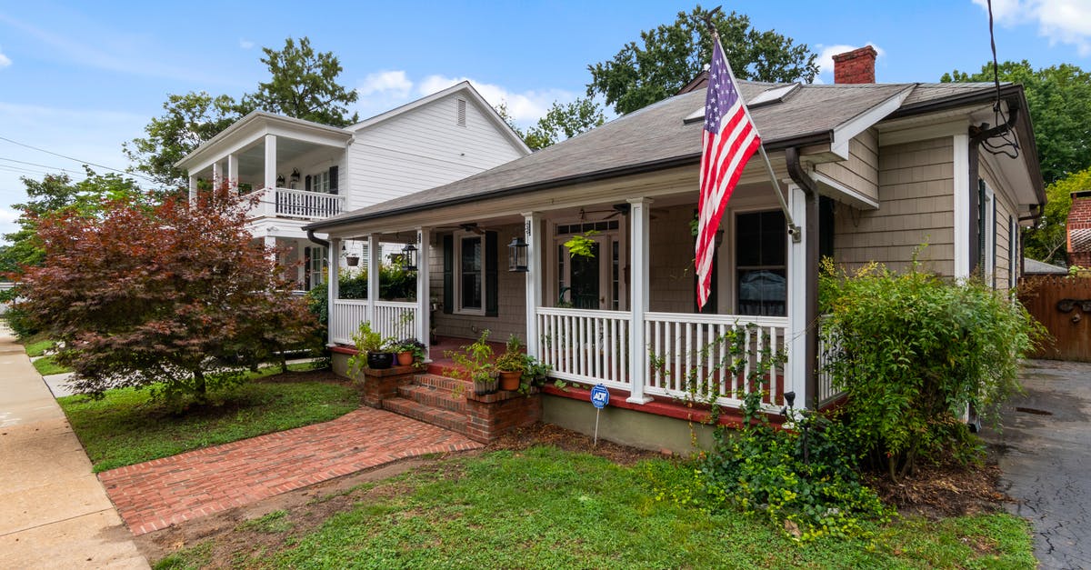 Captain America Shield Deflection - American Bungalow House with a Flag Attached to a Porch 
