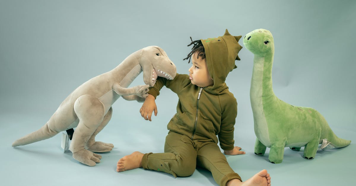 Cartoon similar to Transformers, with two gangs, good and bad [closed] - African American child with dreadlocks in dinosaur costume sitting between soft toys representing bite concept