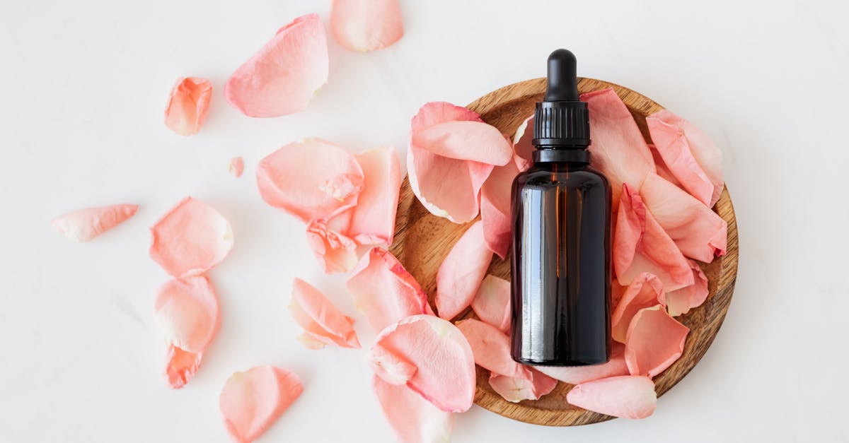 Connection between Jar Jar Binks and the film "Alice"? - Top view of empty brown bottle for skin care product placed on wooden plate with fresh pink rose petals on white background isolated