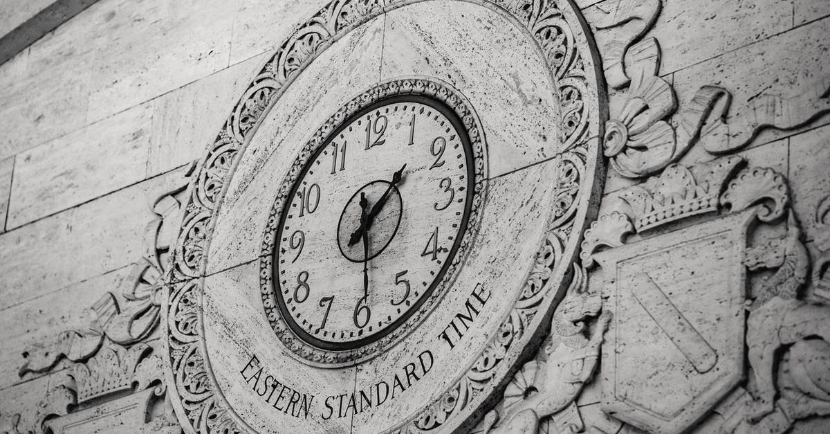 Cooking shows' last minute finishes - From below black and white of stone wall with ornamental details around clock showing Eastern Standard Time