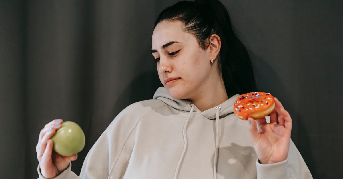 Could there have been an alternative decision made for Werner? [closed] - Pensive female wearing casual hoodie deciding between healthy green apple and sweet doughnut in studio