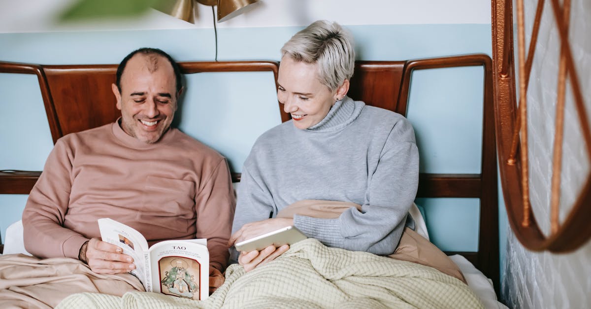 Could Truman's wife be considered to be a prostitute under the governing laws of California? [closed] - Happy diverse couple smiling and reading book together while resting in bed