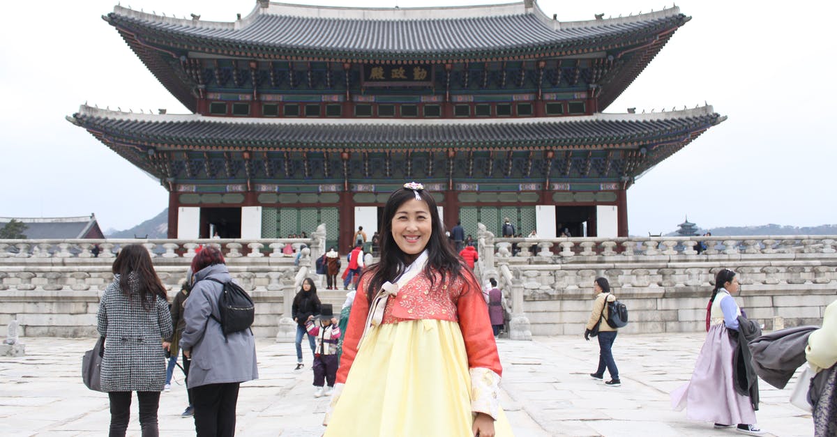 Cultural Basis of Asian Ghost Lady - Positive Asian female tourist wearing long yellow dress standing on square in front of pagoda during vacation