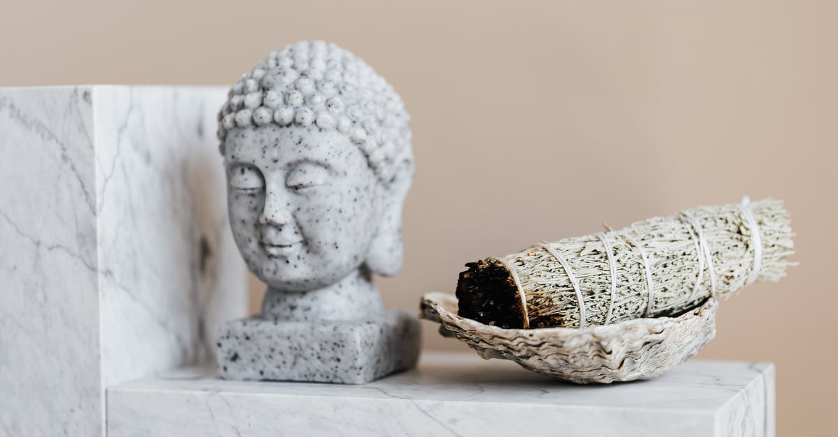 Diction in original vs remake of True Grit - Bust of Buddha and dry sage bundle on marble surface