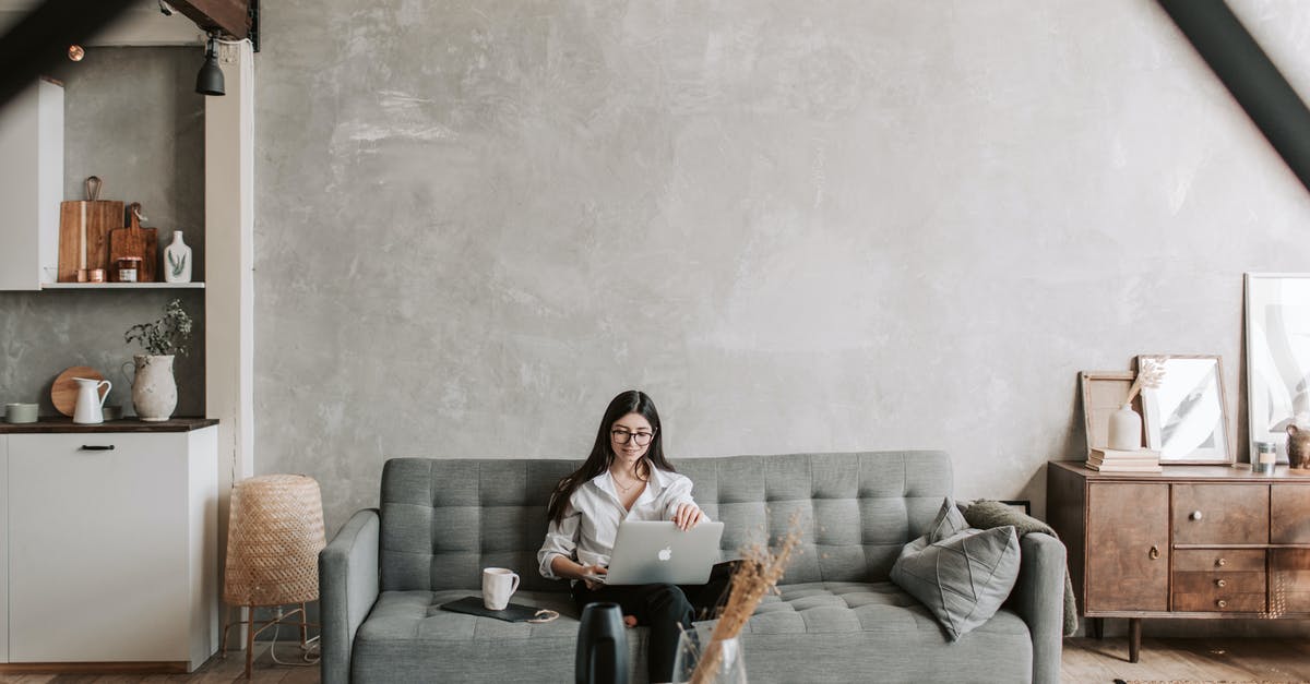 Did Brian Finch break the fourth wall? - Happy female remote worker in eyeglasses sitting on cozy sofa with netbook and cup of coffee in loft style room with wooden floor and concrete wall