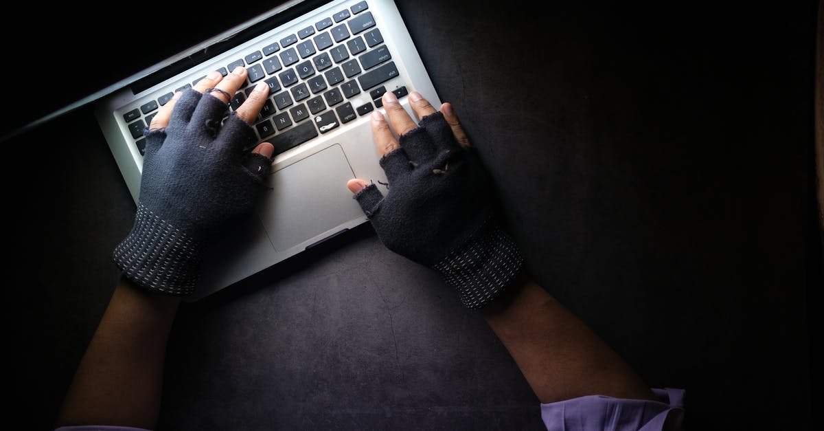 Did Loki steal the Tesseract? - A Person Typing on Laptop while Wearing a Fingerless Gloves
