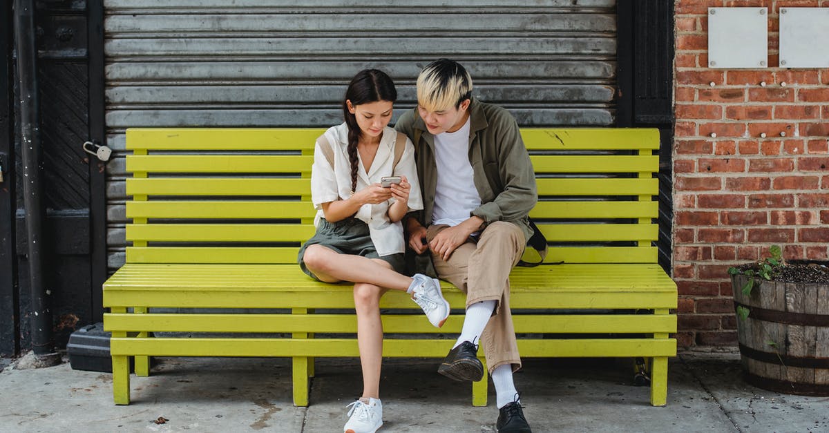 Did Sesame Street use to contain "Monster Time"? - Serious multiracial couple resting on yellow bench and browsing smartphone and looking at screen