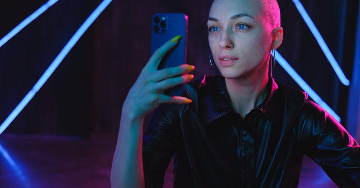 Did the moment when the Chinese general tells his phone number actually happen? [duplicate] - Young Bald woman using photos on smartphone in neon studio