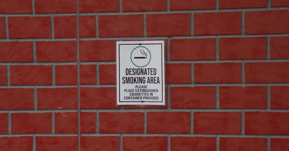 Did they allow smoking in the USA Courts in 1960s? - Building with brick wall and signboard with title indicating smoking area with symbol of cigarette