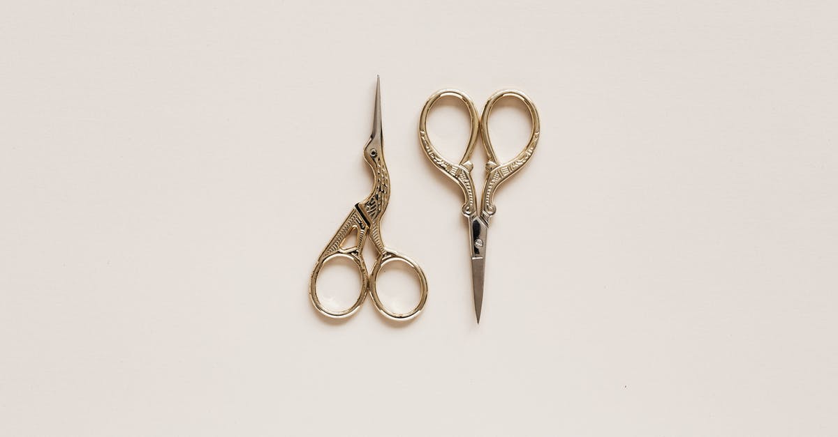 Did they shoot a different ending? - Top view composition of scissors of various shape with carved ornament on beige table