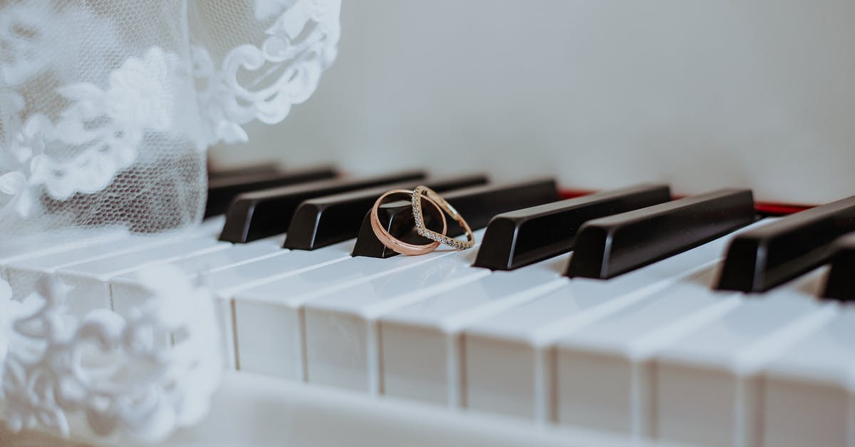 Difference between The Ring and Ringu - Golden rings on piano keyboard under veil with ornament during festive event in daytime