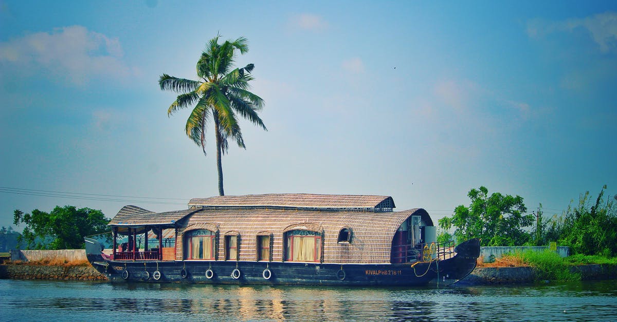 Do film industries outside India use intervals/Intermission? - Picturesque view of river with green palms on bank and shabby wooden boathouse under blue sky in tropical countryside