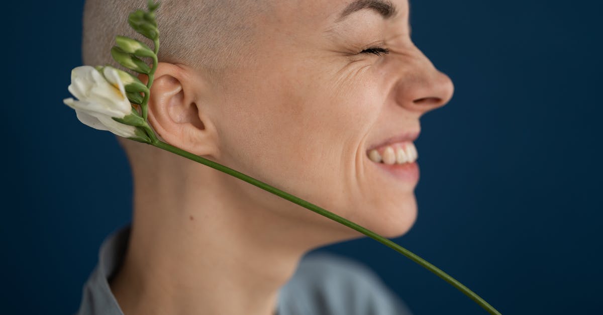 Do patients experience tastes during brain surgery? - Side view of crop cheerful female patient with blossoming flower representing scar on head concept after brain tumor surgery on blue background