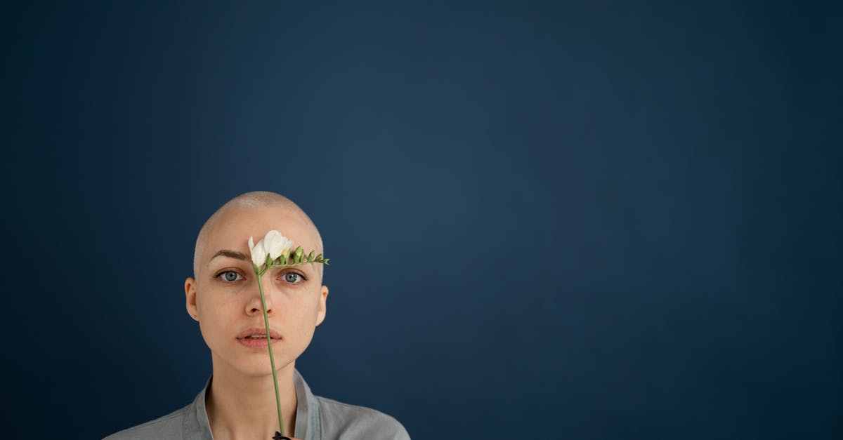 Do patients experience tastes during brain surgery? - Young reflective female patient looking at camera with blooming flower representing cicatrice on forehead concept after cancer operation
