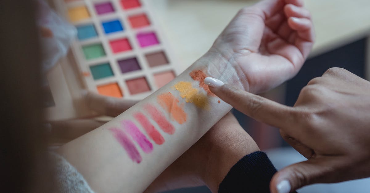 Do production companies ever "choose" their test audience? - From above of crop unrecognizable young female makeup artist pointing at arm of client while applying colorful eyeshadows on wrist for testing