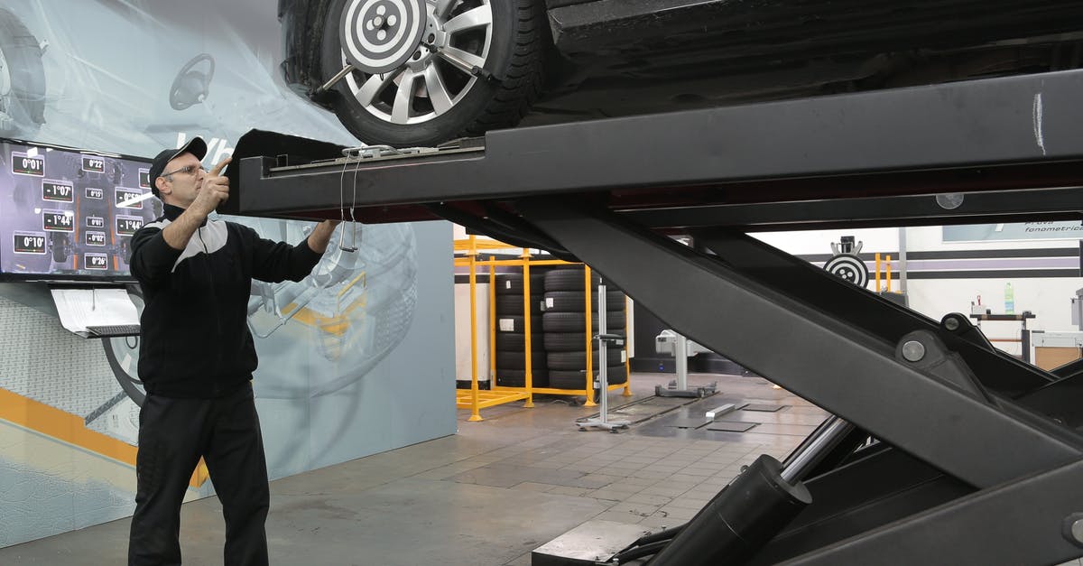 Do production companies ever "choose" their test audience? - Serious mechanic checking car wheels on lift in modern car service garage