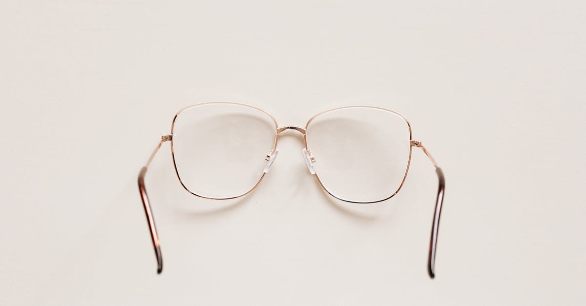 Do we ever see any visions in the fire? - Top view of fashion spectacles with transparent optical lenses in golden metal shell placed on white table