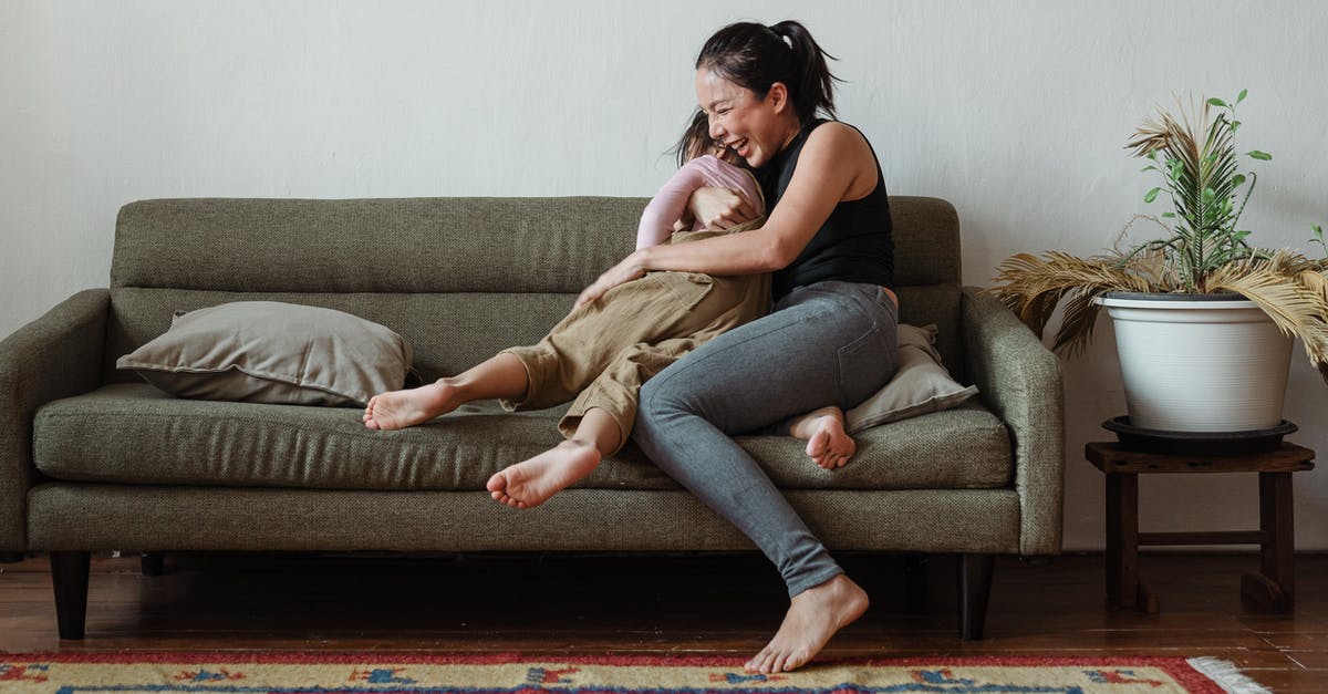 Does Alita have a third body? - Photo of Woman Sitting on Couch While Hugging Her Child