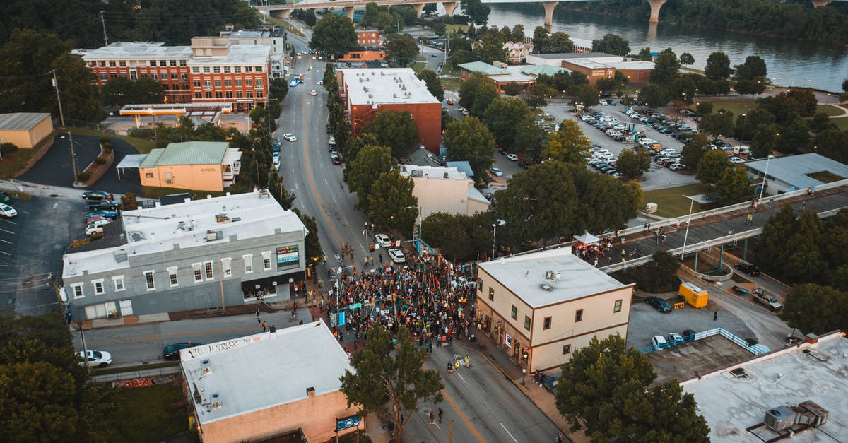 Does Carrie know about the drone strike Walden authorised - Aerial view of unrecognizable group of people on road during manifestation between buildings in city