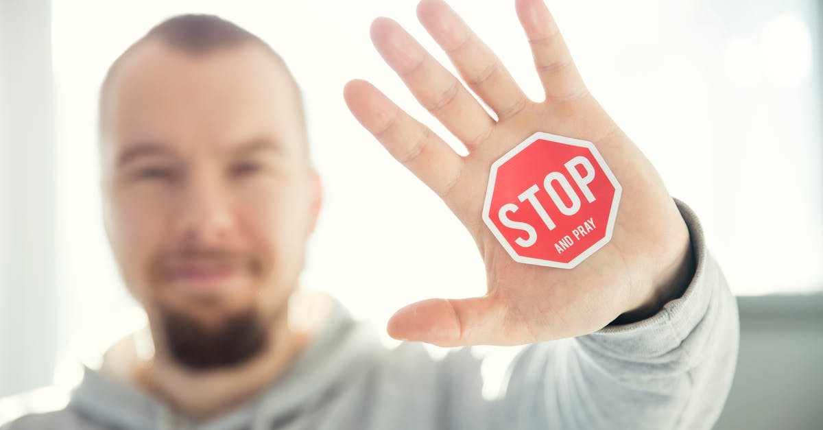 Does Dr No have all his fingers? - Photography of a Persons Hand With Stop Signage