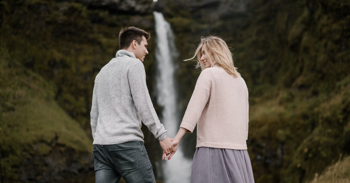 Does Happy! season 2 end on a cliff hanger? - From below back view smiling couple standing on mountainous valley against spectacular view of waterfall and holding hands while looking at each other