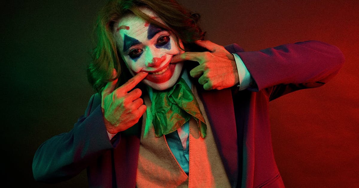 Does Joker kill this character in the end? - Dramatic male clown with painted face grimacing smile pulling mouth with hands while looking at camera