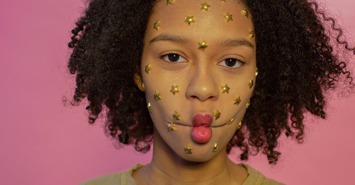 Does STAR Labs have a revenue model? - Young African American female with yellow star rhinestones on face looking at camera while making fish lips on pink background