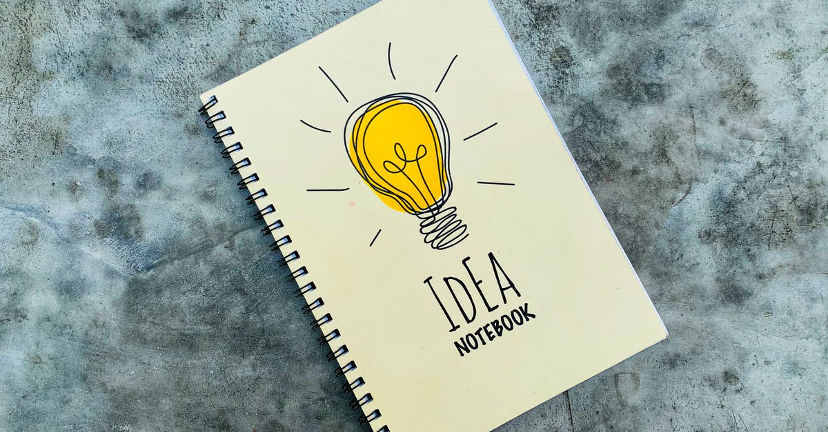 Does the Thinker know about the power of metas he created? - Top view of creative spiral notebook with yellow light bulb illustration on cover placed on gray table