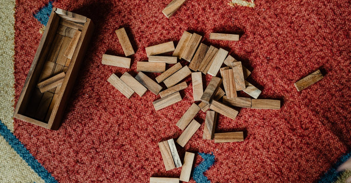 Does the wooden puzzle from Tomb Raider really exist? - Top view of wooden box and pile of blocks for playing in jenga tower game arranged on floor carpet