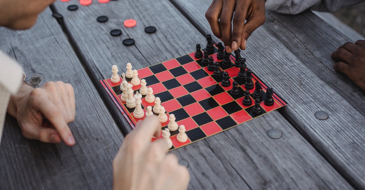 Does time-leaping move your mind or your body? - Unrecognizable multiracial male millennials playing chess at wooden table