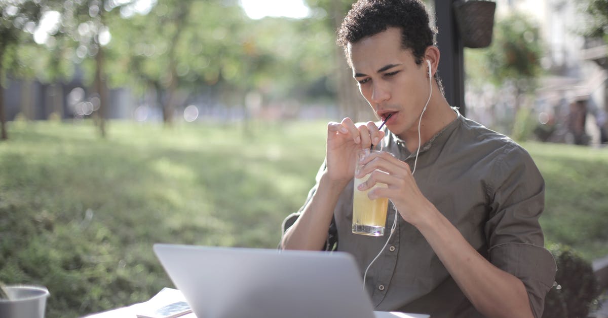 Eastern European cold war movies - Black man drinking lemonade in cafe and using laptop