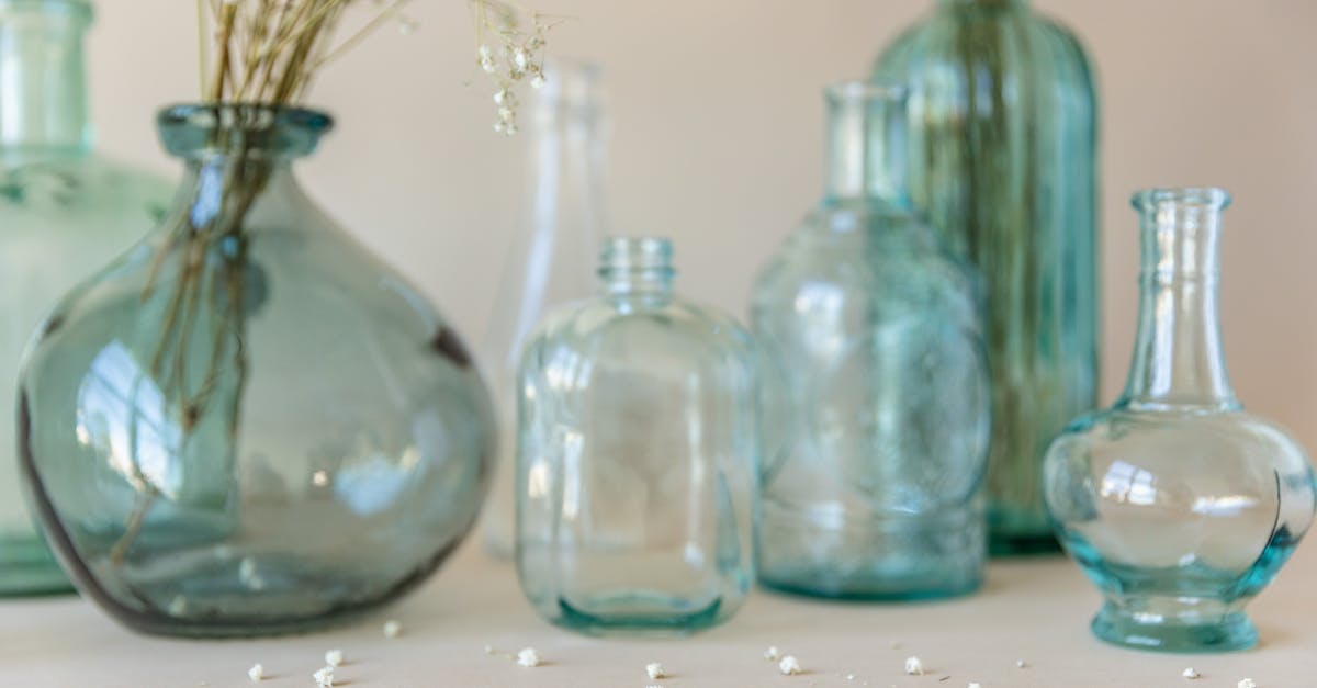 Elise's presence in the further - Three Clear Glass Bottles on White Table