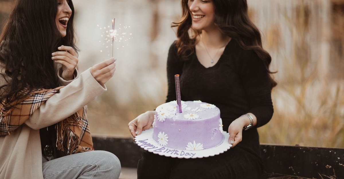 Explanation for A Tale of Two Sisters? - Two Lovely Women Sitting Outdoors with Birthday Cake and Sparkler