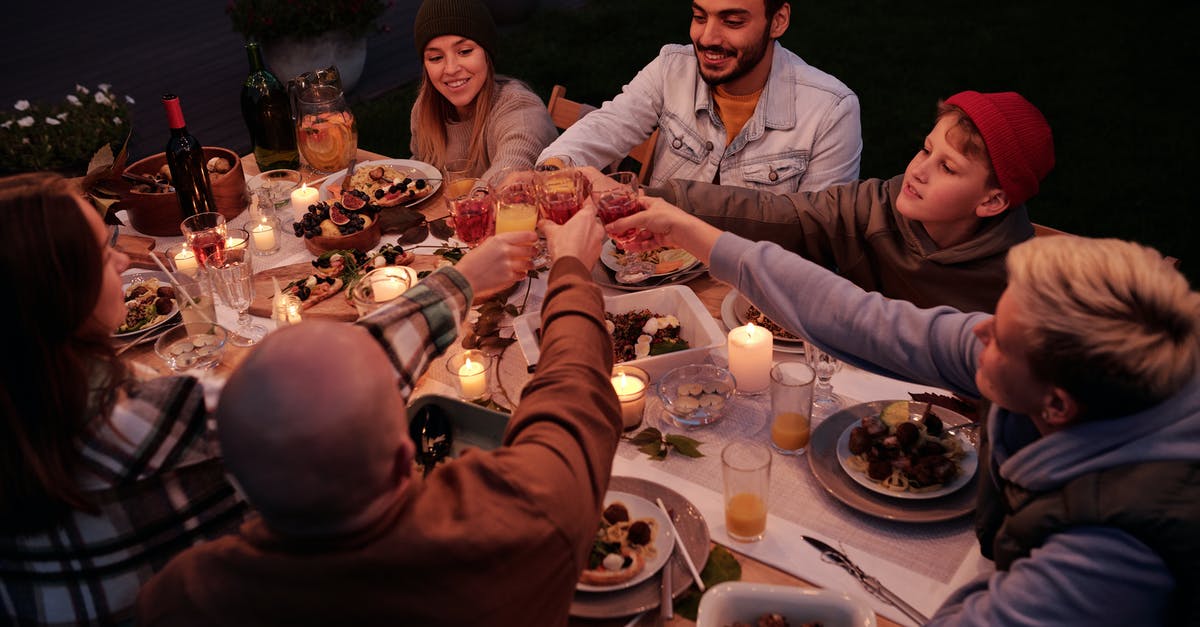 Exposing Alcohol in films to kids or teens - From above multiethnic people with children spending evening at dinner in dusky garden and cheering with drinks