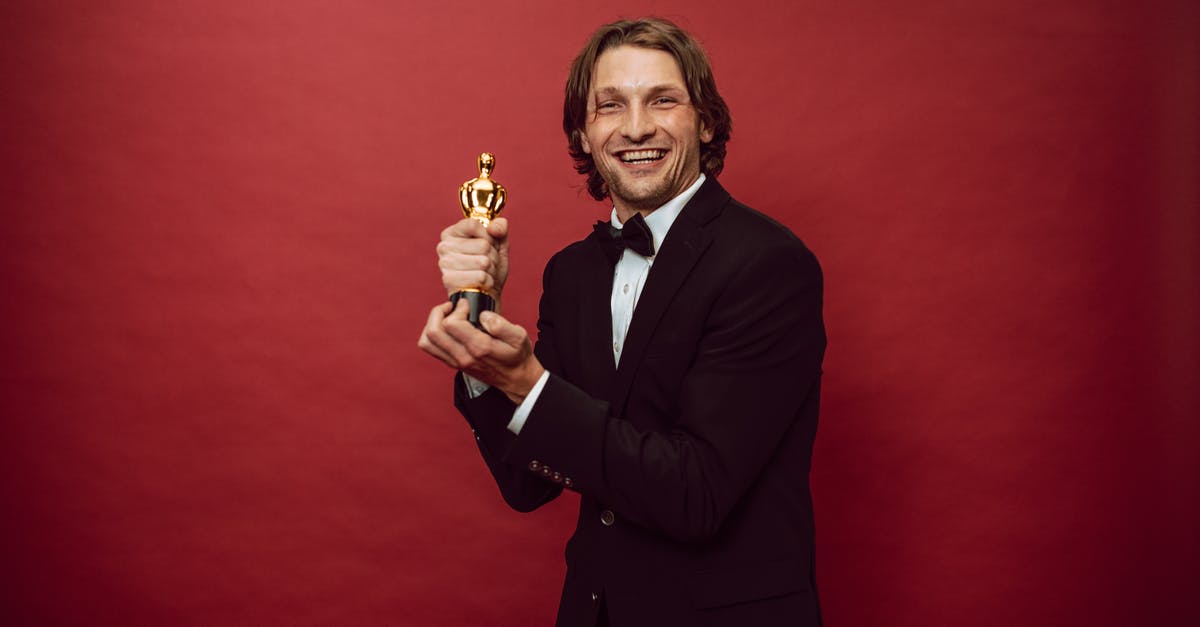 First Best Actor Oscar for war movie - A Happy Man in a Black Suit Holding His Trophy