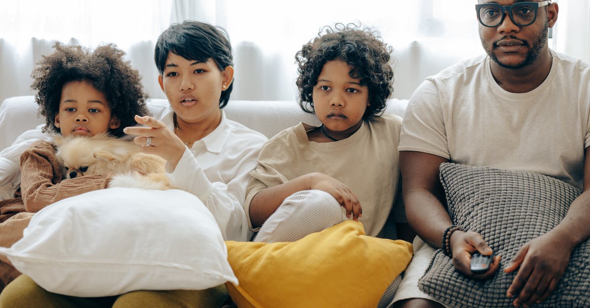 First Movie or TV Show to use "The Volume"? - Multiethnic family watching TV with dog on sofa