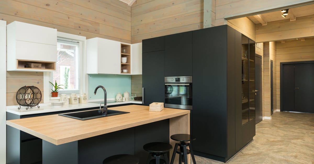 First occurrence of a house built on a graveyard? - Minimalist style of kitchen with bar chairs at counter and matte cupboards in spacious private house