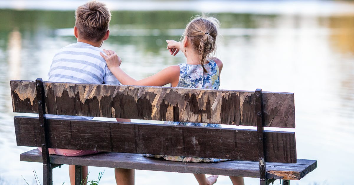Girl looks into mirror, sees demon swimming towards her [closed] - Selective Focus Photography of Boy and Girl Sitting on Bench Near Lake
